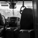 Een buschauffeur in uniform die in een stadsbus zit en passagiers verwelkomt.